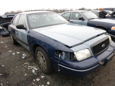 1991 Ford LTD Crown Victoria - This Ford Crown Victoria has a two-tone paint job and is missing a headlight. A second Crown Victoria is parked behind it.