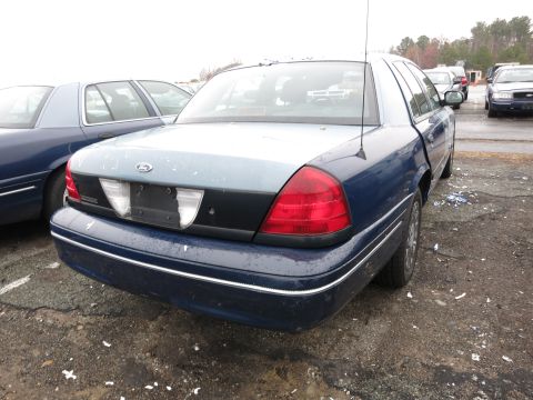 1991 Ford LTD Crown Victoria - Rear view of a blue Ford Crown Victoria with a two-tone trunk and chrome trim, parked in an outdoor lot.