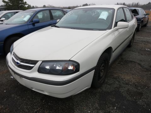 1991 Ford LTD Crown Victoria - A white sedan is parked in a lot with other vehicles. Papers are visible on the dashboard.
