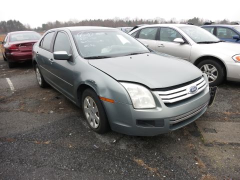 1991 Ford LTD Crown Victoria - A gray Ford Fusion is parked in a lot with other vehicles. Text on the windshield indicates the year 2006.