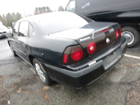1991 Ford LTD Crown Victoria - Rear view of a black sedan, possibly a Chevrolet Impala, parked next to a van.