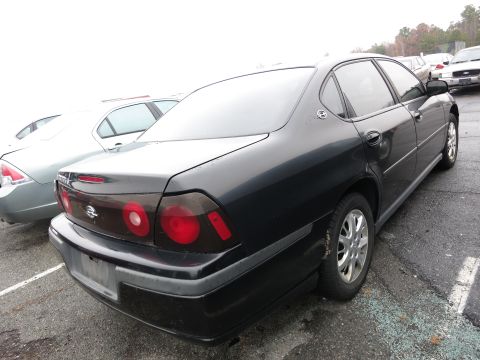 1991 Ford LTD Crown Victoria - A black sedan is parked in a lot next to another vehicle.