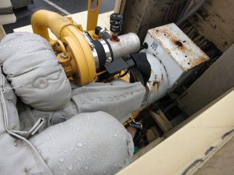 1991 Ford LTD Crown Victoria - Close-up view of a yellow turbocharger and a rusty white generator, both covered in water droplets.
