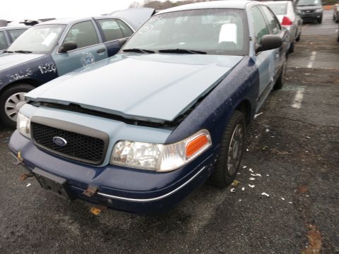 1991 Ford LTD Crown Victoria - A Ford Crown Victoria, likely from the early 2000s, sits with its hood open next to another police vehicle.