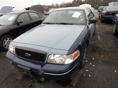 1991 Ford LTD Crown Victoria - A two-tone Ford Crown Victoria sits in a junkyard with other vehicles.