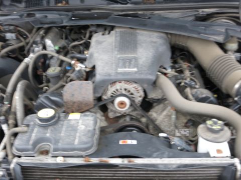 1991 Ford LTD Crown Victoria - The engine bay of a 1991 Ford Crown Victoria LTD, with visible components like the alternator and coolant reservoir.