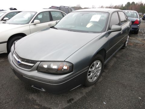 1991 Ford LTD Crown Victoria - A gray Chevrolet Impala is parked in a lot with other vehicles, showing its front end and side profile.