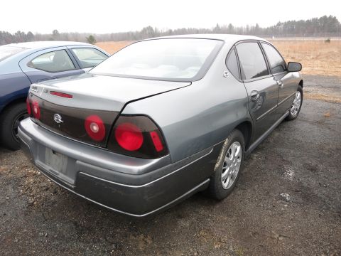1991 Ford LTD Crown Victoria - Rear view of a gray sedan parked next to a blue car, distinctive tinted taillights.