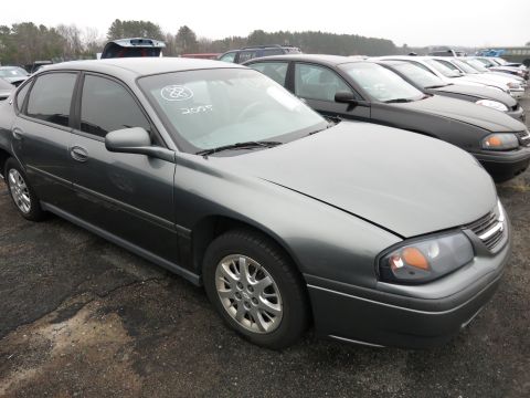 1991 Ford LTD Crown Victoria - A gray sedan is parked in a lot with other vehicles, handwritten numbers on its windshield.