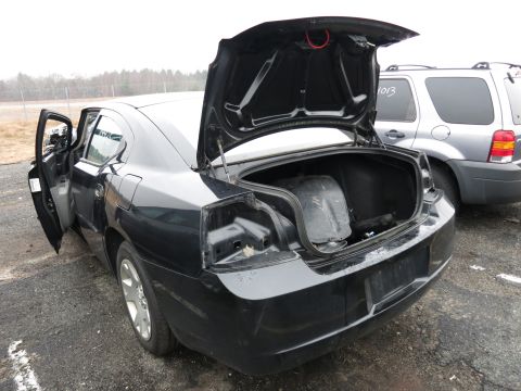 1991 Ford LTD Crown Victoria - A black sedan's trunk and driver's door are open, revealing damage to the rear taillight assembly.