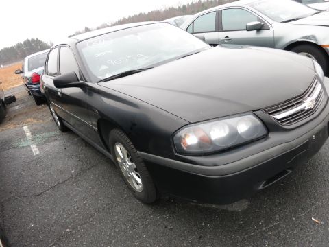 1991 Ford LTD Crown Victoria - A black Chevrolet Impala is parked in a lot with other vehicles. Text is written on the windshield.