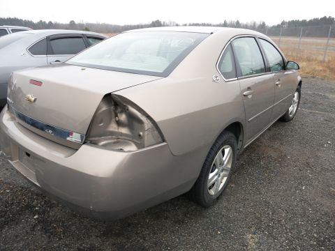 1991 Ford LTD Crown Victoria - Tan sedan with significant rear damage, parked outdoors next to another vehicle.