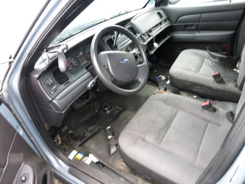 1991 Ford LTD Crown Victoria - Interior of a Ford Crown Victoria showing a damaged dashboard and worn seats, indicating a state of disrepair.