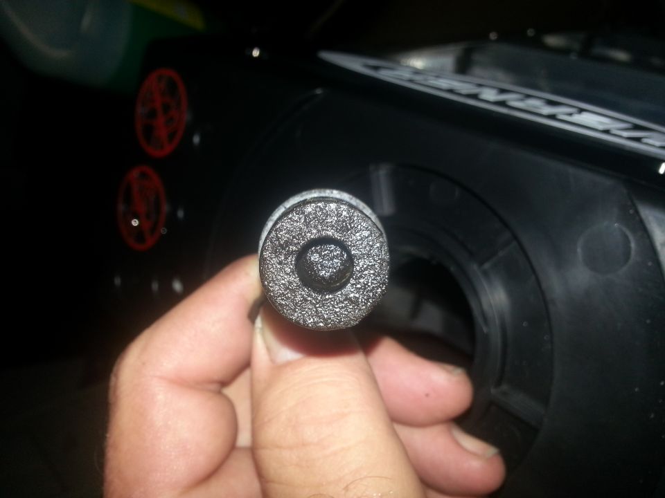 Hand holding a textured cylindrical part with a circular recess