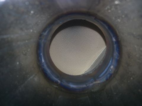 1994 Ford Bronco - Close-up of an exhaust pipe opening showing a mesh screen. Supermotors.net logo is visible.