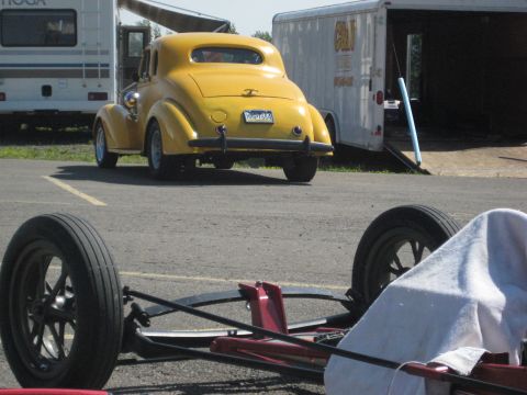 1935 Chevrolet new - A yellow coupe with a distinctive rounded rear is parked in front of a trailer.