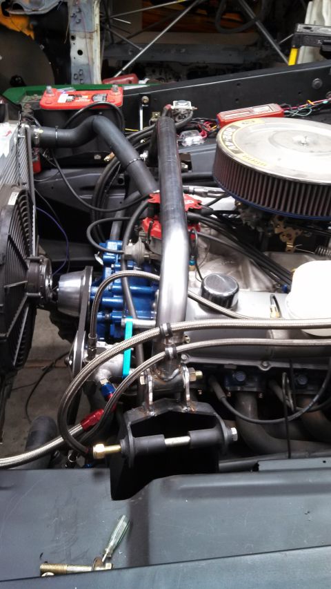 1967 Ford F-250 - Custom exhaust pipe installed in the engine bay of a vehicle.
