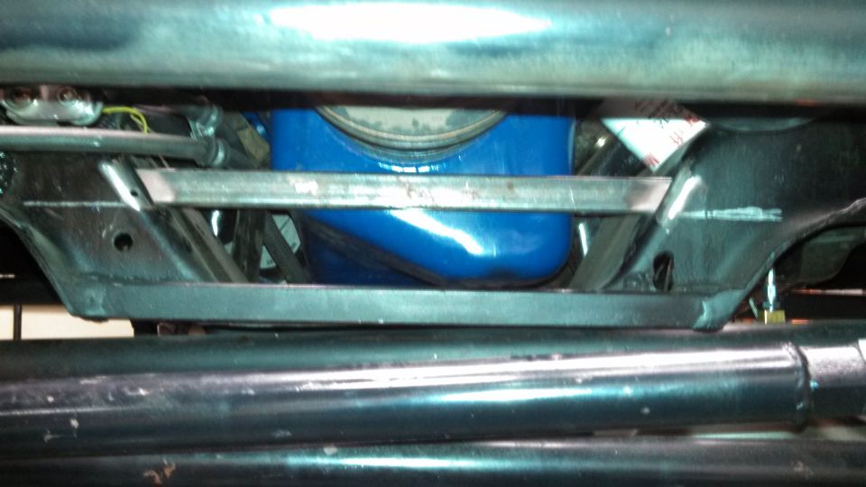 Close-up of vehicle undercarriage showing a blue oil pan and suspension components