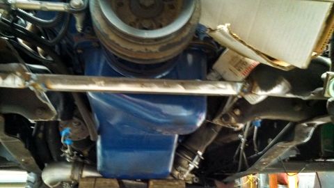 1967 Ford F-250 - Underside view of a vehicle's engine compartment, focusing on the blue oil pan and exhaust system.