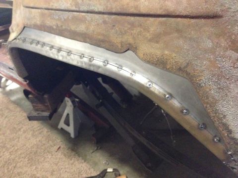 1964 Ford Fairlane - A close-up view of a car's rusty rear fender area with a newly fabricated and welded metal flare installed.