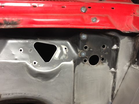 1964 Ford Fairlane - The firewall of a vehicle shows raw metal and red paint, indicating repair or modification work.