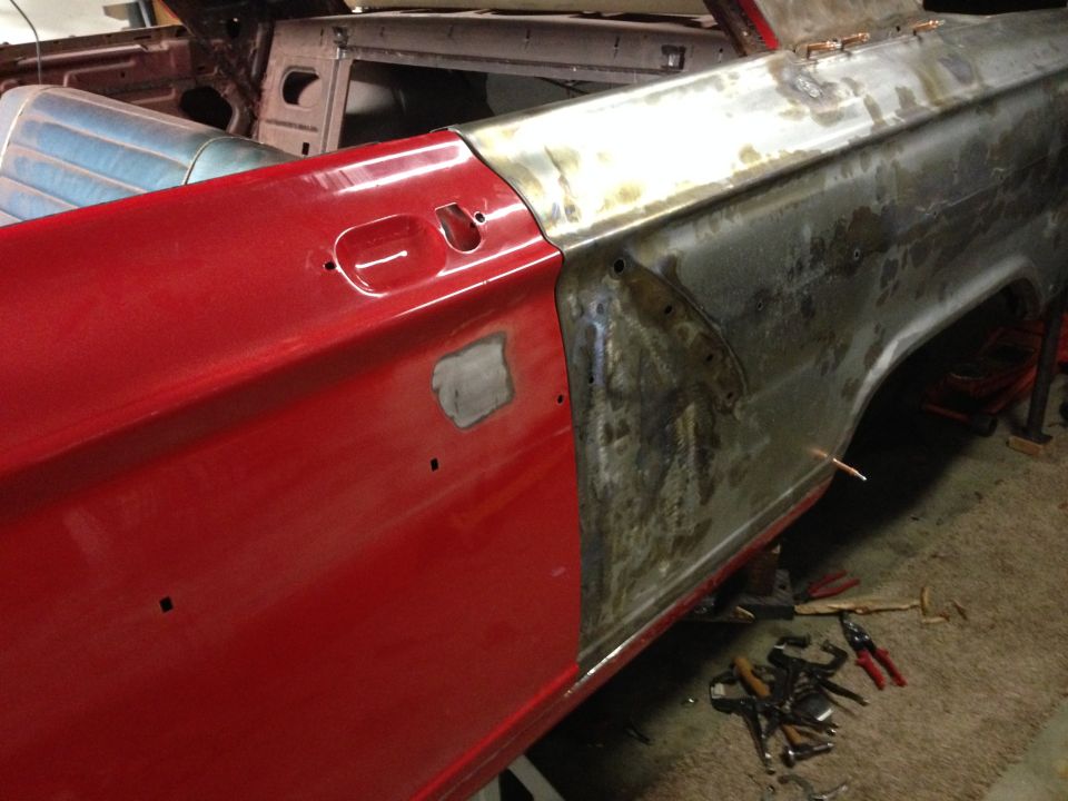 Car door and fender being worked on, showing red paint and bare metal