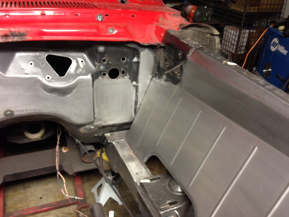 Car firewall and inner fender area, showing metal work and some wiring