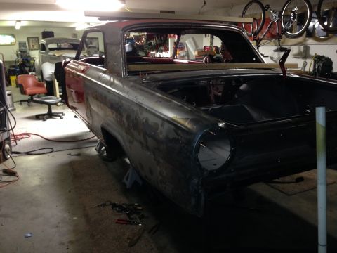 1964 Ford Fairlane - A 1964 Ford Fairlane body is undergoing restoration in a garage, with another vehicle visible in the background.