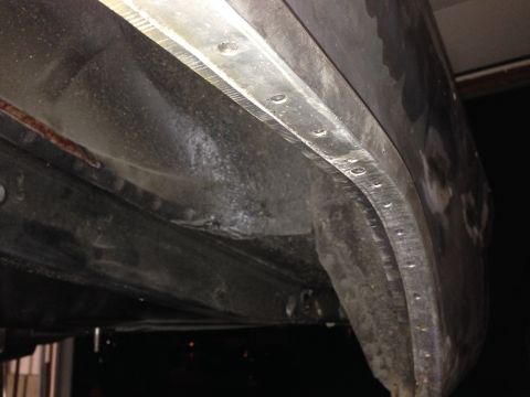 1964 Ford Fairlane - Detail of the inner fender and trim on the underside of a vehicle.