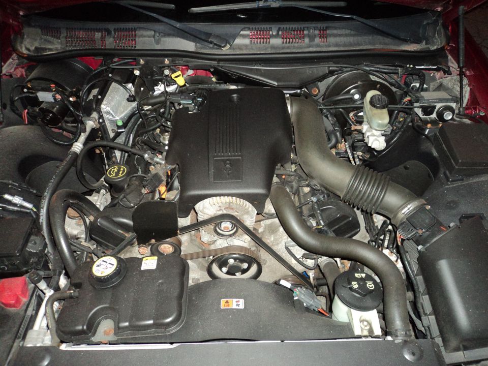 Engine bay of a 2004 Mercury Grand Marquis. Shows the V8 engine, air intake, and coolant reservoir