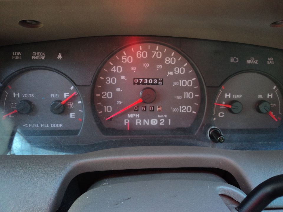 Dashboard gauges of a 2004 Mercury Grand Marquis showing 73,030 miles and fuel, voltage, temperature, and oil levels