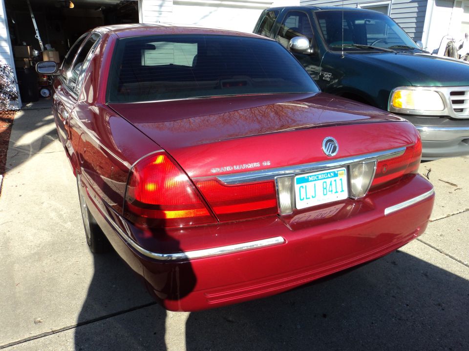 Red 2004 Mercury Grand Marquis sedan rear view with Michigan plate CLJ 8411