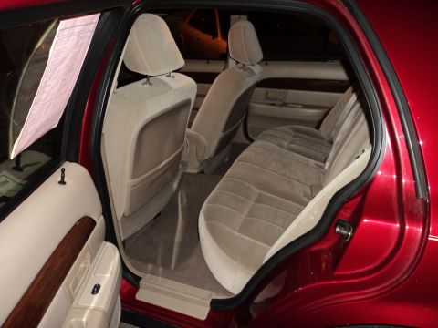 2004 Mercury Grand Marquis - Interior view of a red sedan, showing tan cloth seats and wood trim accents.
