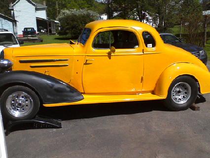 1935 Chevrolet new - A yellow coupe with black fenders and custom wheels is parked outdoors.