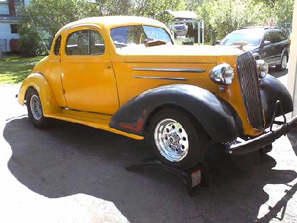 1935 Chevrolet new - A yellow 1935 Chevrolet New coupe is shown from the front three-quarter angle.