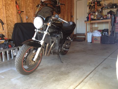 1998 Suzuki Bandit - A black Suzuki motorcycle is parked in a garage with tools and storage in the background.