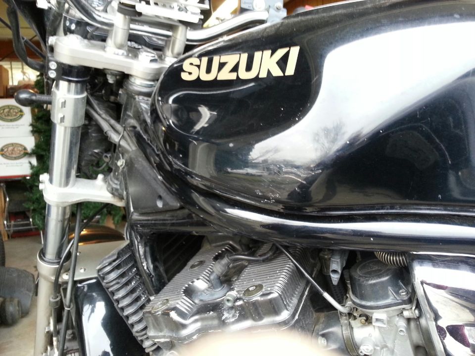 Close-up of a black Suzuki motorcycle's fuel tank and engine components