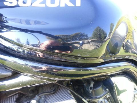 1998 Suzuki Bandit - A close-up view of a black Suzuki motorcycle's fuel tank and engine details.