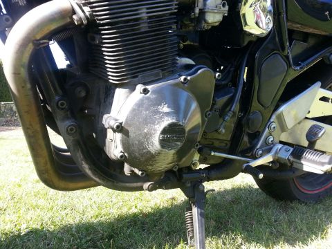 1998 Suzuki Bandit - Close-up view of a motorcycle's engine, the Suzuki branding on the crankcase cover.
