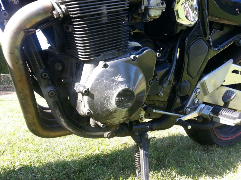 Motorcycle engine with visible "SUZUKI" logo on the side cover
