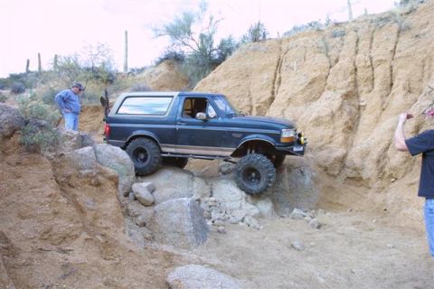 1994 Ford Bronco - A modified 1992 Ford Bronco navigates a rocky desert terrain, demonstrating its off-road capabilities.