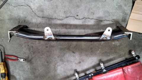 1967 Ford F-250 - Custom metal fabrication part with mounting brackets shown on a concrete floor next to tools.