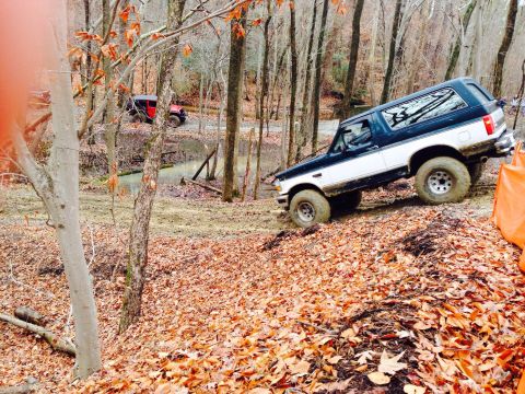1979 Ford Bronco - Ford Bronco navigating an off-road trail with another vehicle visible in the distance.
