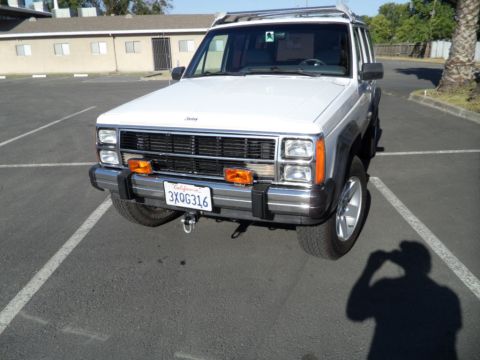 1994 Jeep Cherokee - This white 1994 Jeep Cherokee is shown from the front, its distinctive grille and orange marker lights.