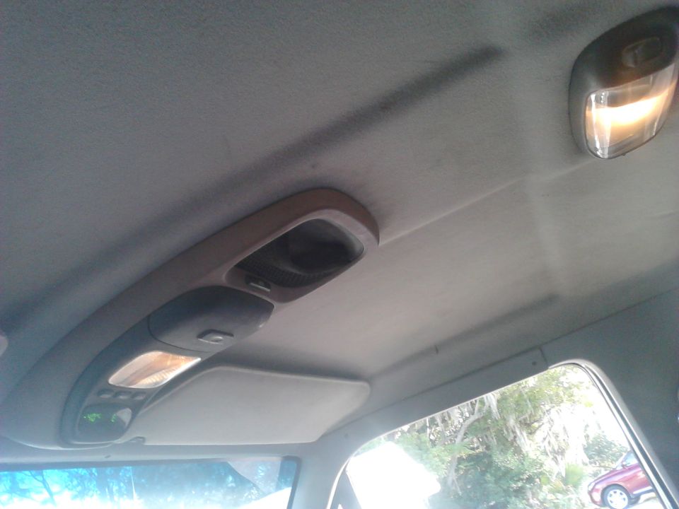 Gray headliner and overhead console with map lights in a 1996 Ford Bronco interior; rear dome light illuminated.