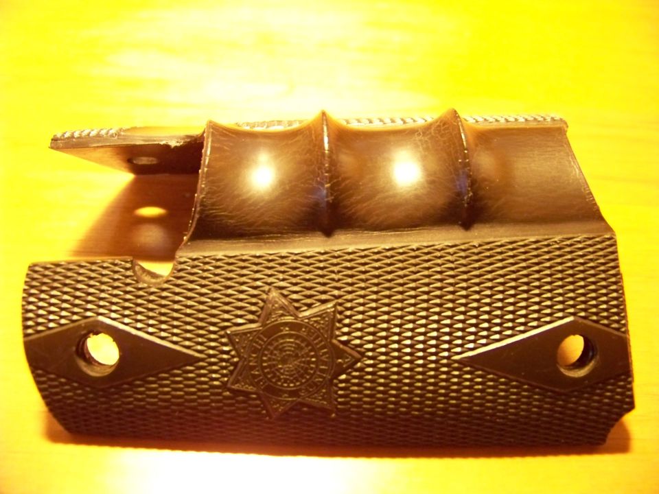 Dark gun grip with star emblem and textured pattern. Supermotors.net logo visible