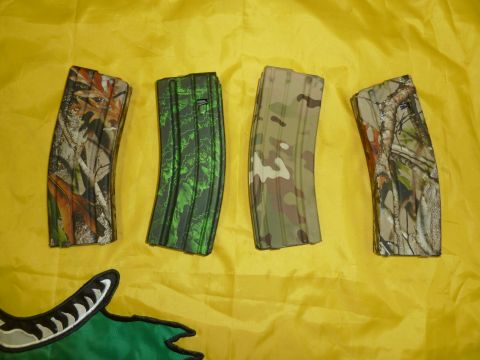 1992 Ford Mustang - Four rifle magazines, each with a unique camouflage pattern, are displayed on a yellow fabric background.