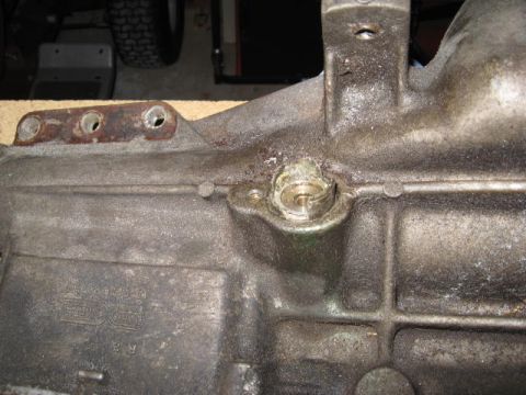 1966 Ford Falcon - A close-up view of a metal component, possibly a transmission housing, showing a circular fitting and mounting points.