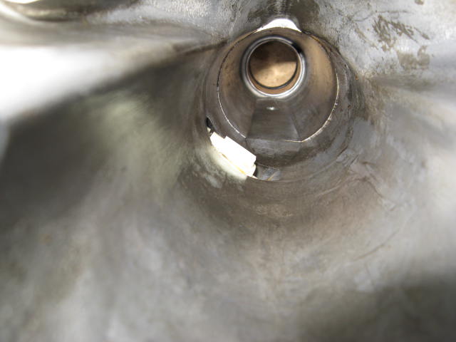 Inside view of a metal exhaust pipe, showing wear and some damage