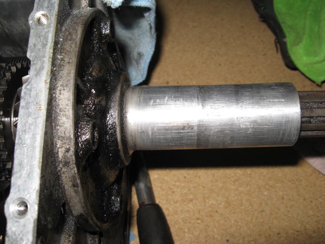 Close-up of a greasy automotive part with a splined shaft extending from a metal housing